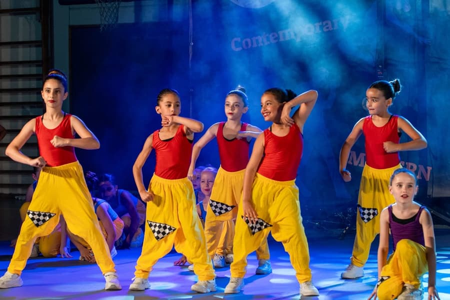 ילדות בגופיות אדומות ומכנסיים צהובים בתנוחת היפ-הופ